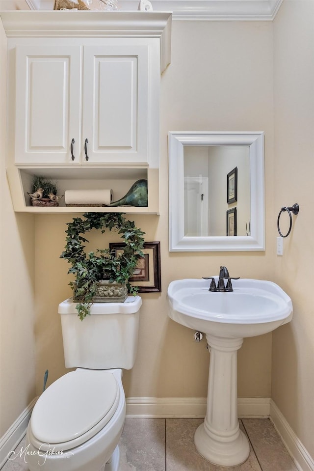bathroom with toilet, tile patterned flooring, and baseboards