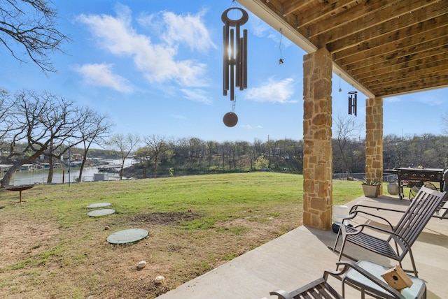 view of yard with a water view and a patio area