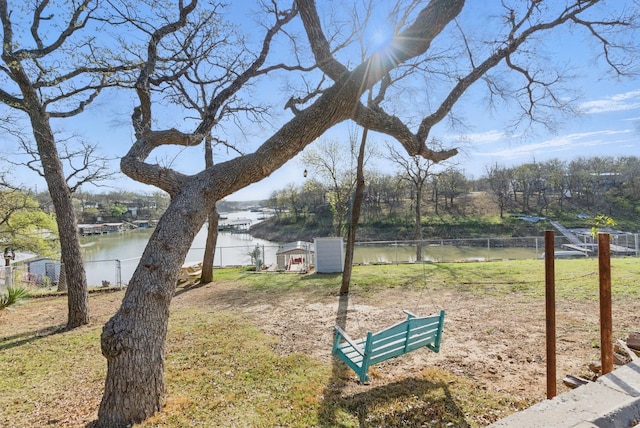 view of yard with a water view and fence