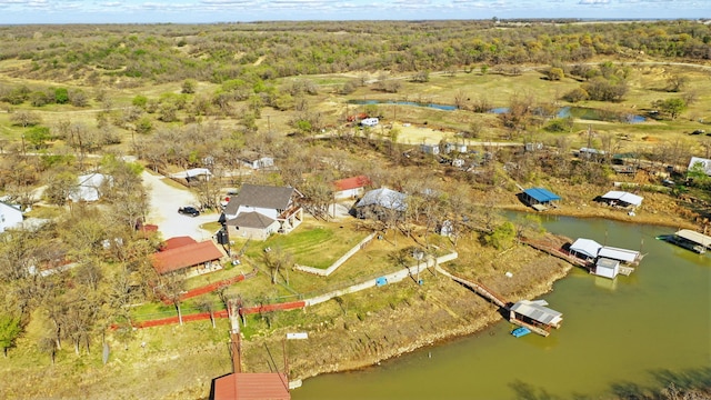 birds eye view of property with a water view and a wooded view