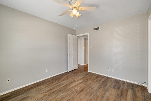 spare room featuring ceiling fan, baseboards, visible vents, and wood finished floors