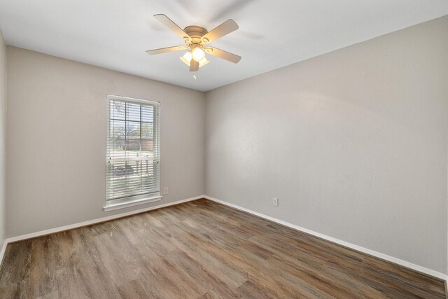 spare room with baseboards, ceiling fan, and wood finished floors