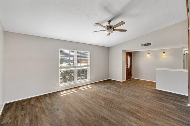 spare room featuring a ceiling fan, baseboards, wood finished floors, vaulted ceiling, and visible vents