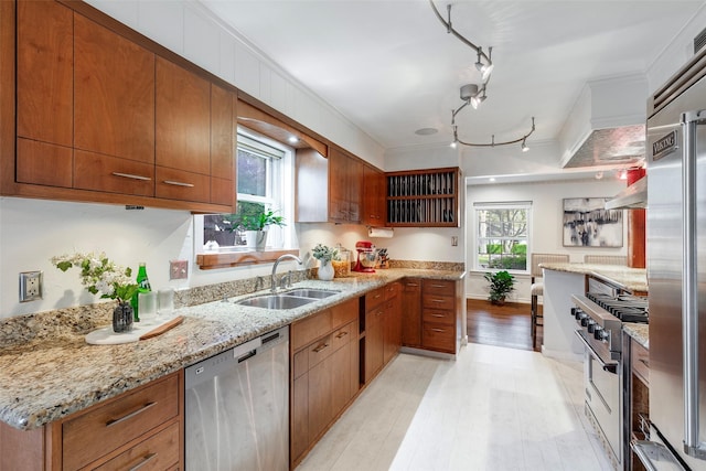 6814 Blackwood Dr, Dallas, TX 75231 - kitchen with premium appliances, a sink, light wood finished floors, brown cabinets, and light stone countertops