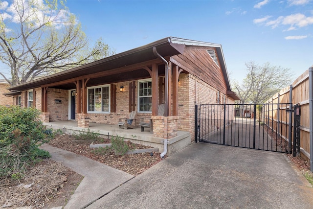 6814 Blackwood Dr, Dallas, TX 75231 - view of front of home featuring brick siding, covered porch, and a gate