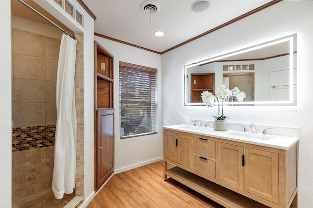 6814 Blackwood Dr, Dallas, TX 75231 - bathroom featuring wood finished floors, double vanity, crown molding, baseboards, and tiled shower