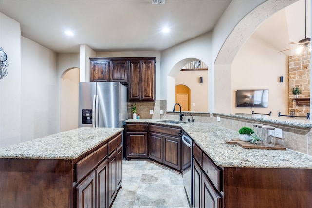 3533 Hutch Dr, Plano, TX 75074 - kitchen featuring dark brown cabinets, light stone countertops, a sink, stone finish flooring, and appliances with stainless steel finishes