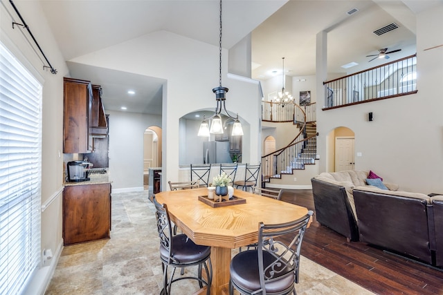 3533 Hutch Dr, Plano, TX 75074 - dining area with arched walkways, a towering ceiling, and ceiling fan with notable chandelier