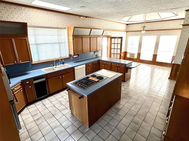 kitchen with a sink, a textured ceiling, a peninsula, white dishwasher, and wallpapered walls