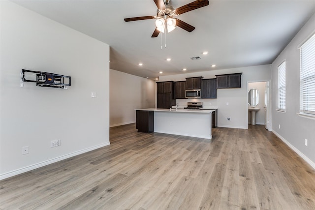 2004 Saddle Way, Mesquite, TX 75149 - kitchen featuring ceiling fan, an island with sink, light wood finished floors, recessed lighting, and stainless steel appliances