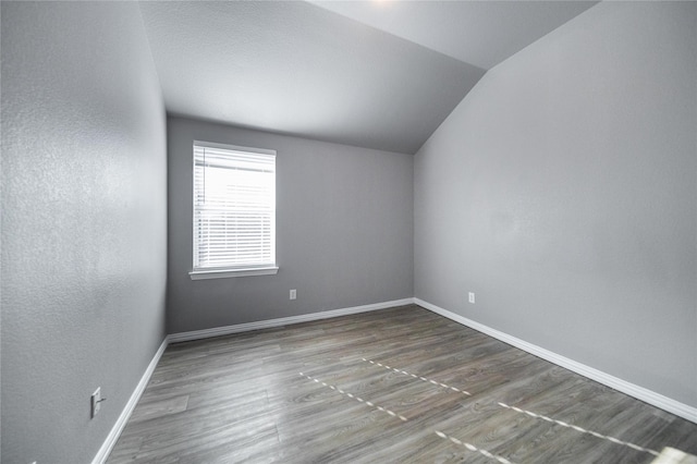 116 Birdbrook Dr, Anna, TX 75409 - empty room with baseboards, vaulted ceiling, wood finished floors, and a textured wall