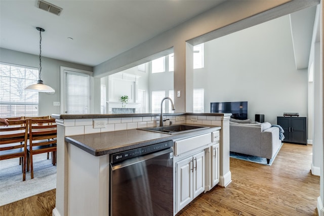 8106 Persimmon St, Irving, TX 75063 - kitchen with dishwasher, a sink, open floor plan, light wood-style flooring, and dark countertops