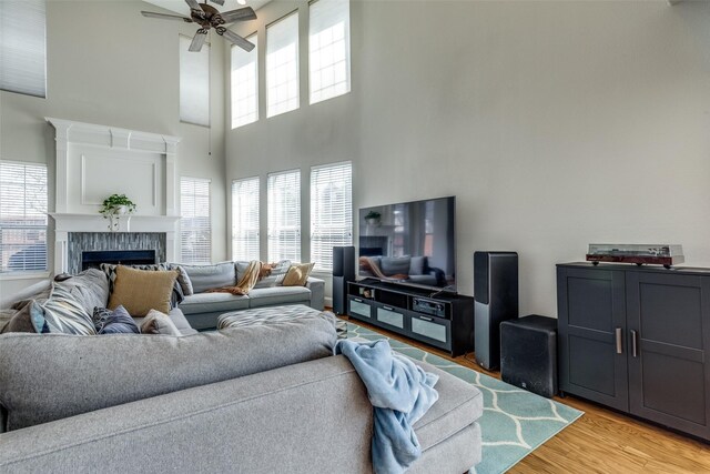8106 Persimmon St, Irving, TX 75063 - living room featuring plenty of natural light, ceiling fan, a high ceiling, light wood-style flooring, and a fireplace