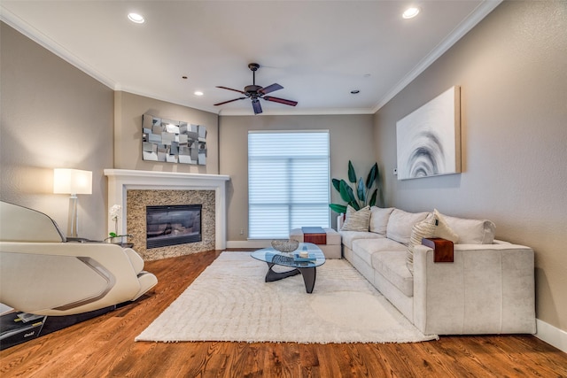living area with ornamental molding, a ceiling fan, recessed lighting, wood finished floors, and a premium fireplace