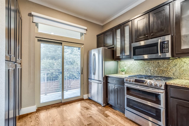 kitchen featuring dark brown cabinets, ornamental molding, appliances with stainless steel finishes, light stone counters, and decorative backsplash