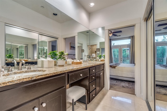 full bath with ensuite bathroom, a sink, ceiling fan, double vanity, and tile patterned floors
