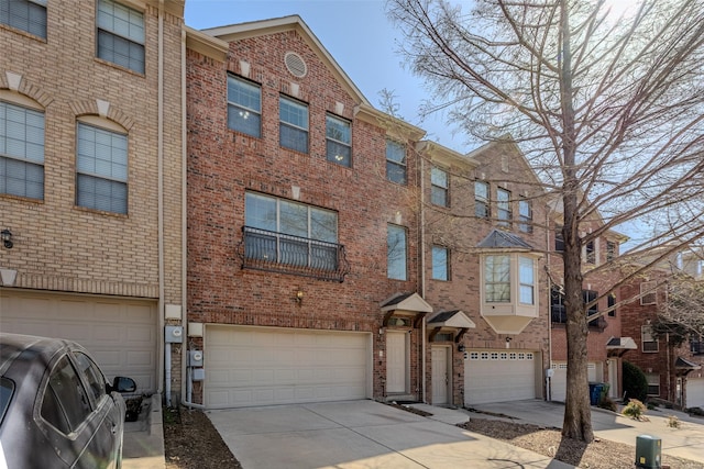 multi unit property with brick siding, concrete driveway, and a garage