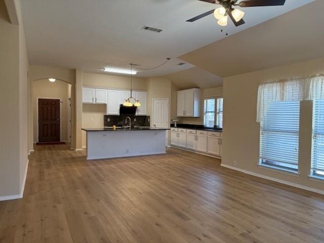 2704 Prescotte Pointe, Mckinney, TX 75071 - kitchen with dark countertops, open floor plan, decorative backsplash, white cabinetry, and vaulted ceiling
