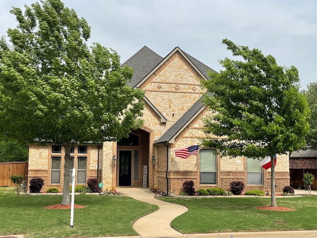 view of front of property with stone siding, a shingled roof, and brick siding