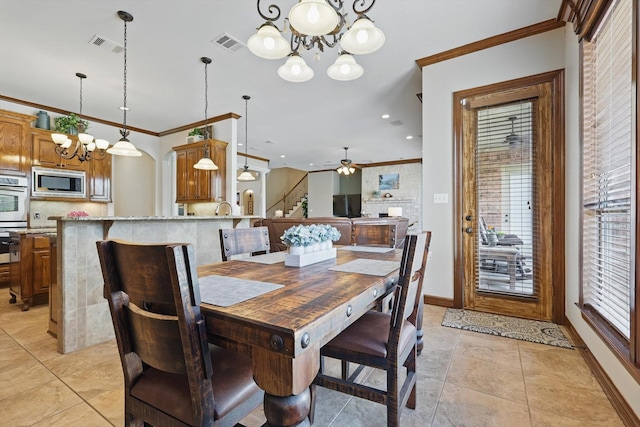 dining area featuring a chandelier, crown molding, stairs, light tile patterned floors, and a ceiling fan