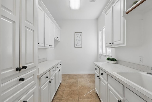 laundry area with baseboards and a sink
