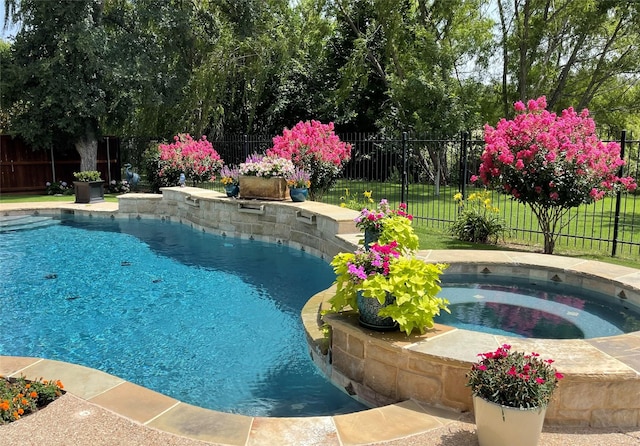 view of pool with an in-ground hot tub and a fenced backyard