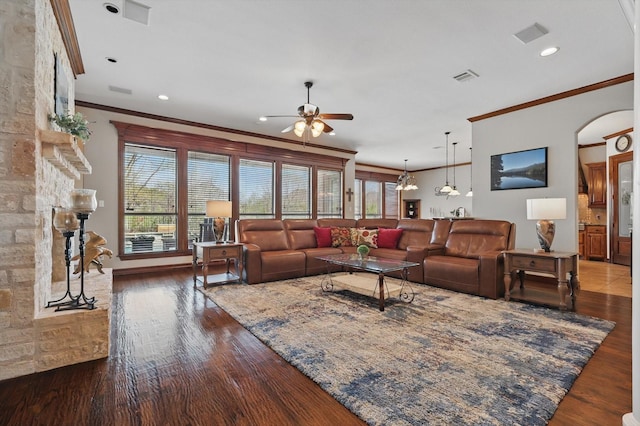 living area with ornamental molding, ceiling fan, wood finished floors, arched walkways, and recessed lighting