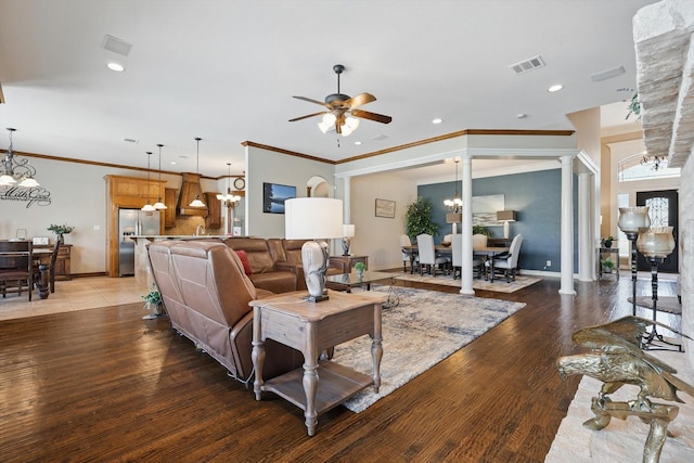 living room featuring ceiling fan, a chandelier, light wood-type flooring, recessed lighting, and crown molding