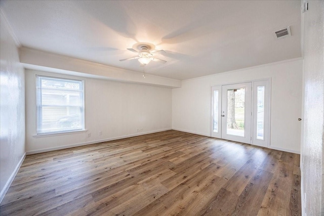 1602 Marion Dr, Garland, TX 75042 - empty room with visible vents, baseboards, ornamental molding, wood finished floors, and a ceiling fan