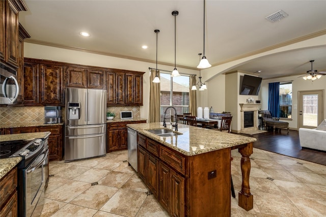 681 Harper Dr, Fate, TX 75087 - kitchen with appliances with stainless steel finishes, a sink, a breakfast bar area, ceiling fan, and decorative backsplash