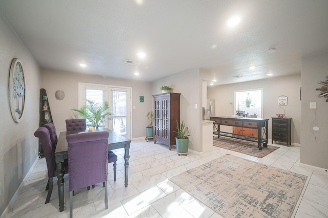 dining area with marble finish floor, a wealth of natural light, visible vents, and baseboards