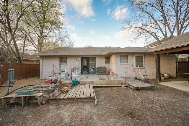 back of property with brick siding, fence, and a patio area