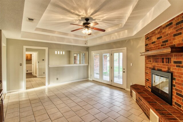 112 Woodcrest St, Weatherford, TX 76087 - unfurnished living room with a tray ceiling, tile patterned flooring, a fireplace, and ceiling fan