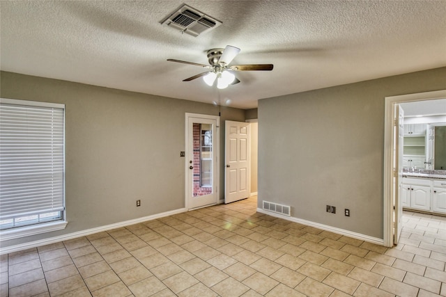 112 Woodcrest St, Weatherford, TX 76087 - spare room featuring ceiling fan, baseboards, a textured ceiling, light tile patterned floors, and a sink