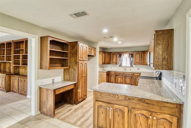 112 Woodcrest St, Weatherford, TX 76087 - kitchen with electric stove, a sink, brown cabinetry, tasteful backsplash, and recessed lighting