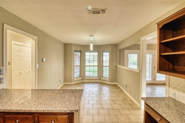 112 Woodcrest St, Weatherford, TX 76087 - unfurnished dining area with light tile patterned flooring, baseboards, and a textured ceiling