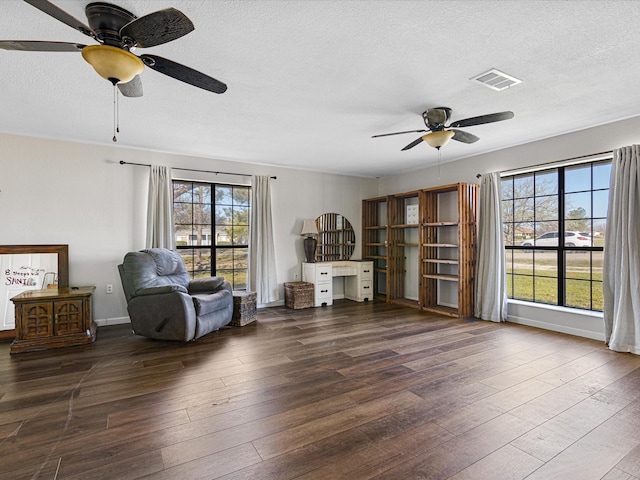 175 Clover Ln, Decatur, TX 76234 - living area with a ceiling fan, a textured ceiling, baseboards, visible vents, and hardwood / wood-style floors