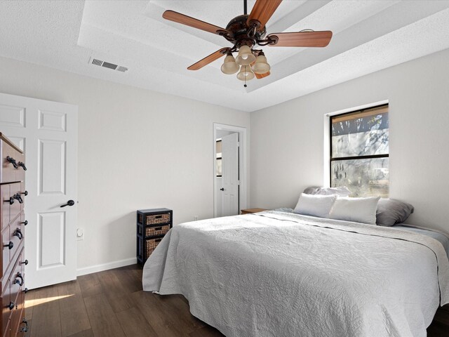 175 Clover Ln, Decatur, TX 76234 - bedroom with baseboards, a textured ceiling, a raised ceiling, dark wood-style floors, and visible vents