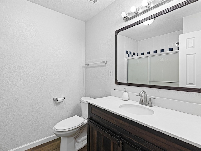 175 Clover Ln, Decatur, TX 76234 - bathroom with a stall shower, toilet, vanity, wood finished floors, and a textured wall