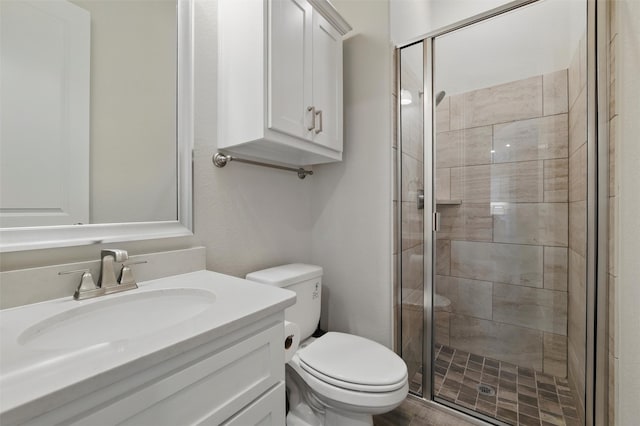 bathroom with toilet, vanity, and a shower stall