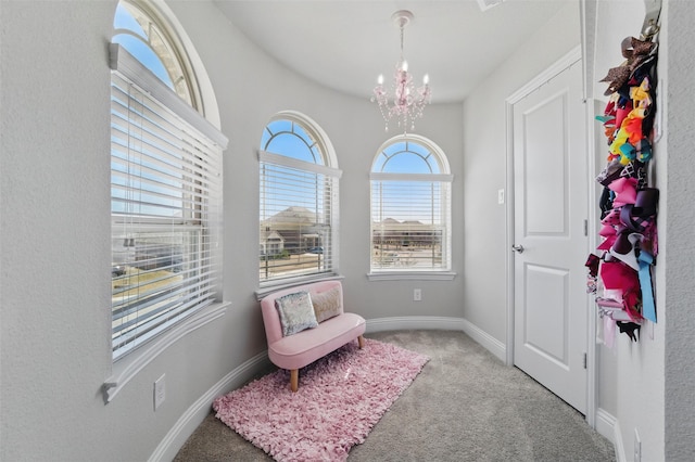 living area featuring baseboards, a notable chandelier, and carpet flooring