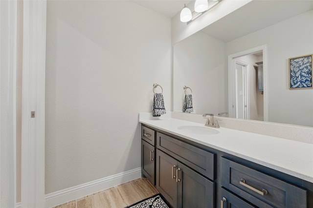 bathroom with vanity, baseboards, and wood finished floors