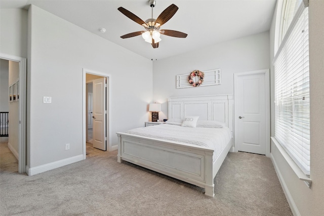 bedroom featuring light carpet, baseboards, and ceiling fan