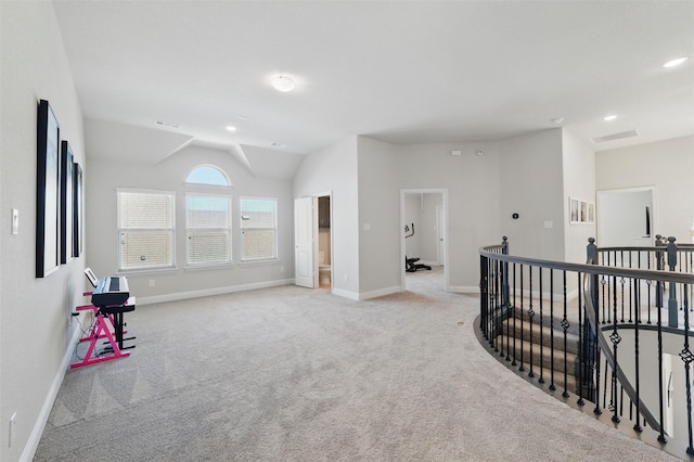 interior space with an upstairs landing, baseboards, light colored carpet, and visible vents