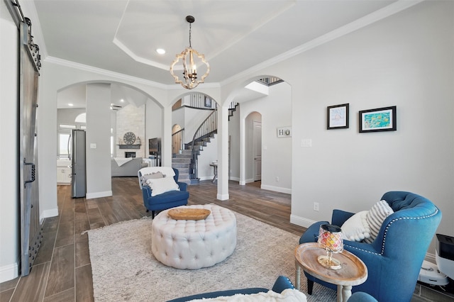 living room featuring arched walkways, a notable chandelier, stairway, and dark wood-type flooring