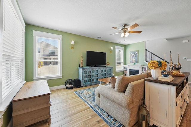 6028 Bowie Ct, Providence Village, TX 76227 - living area with a fireplace, a ceiling fan, wood finished floors, and baseboards
