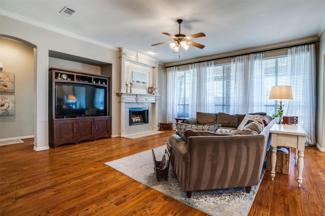 990 Willowmist Dr, Prosper, TX 75078 - living room with ceiling fan, arched walkways, a large fireplace, ornamental molding, and wood finished floors