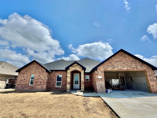 717 Cobblestone Cir, Mabank, TX 75147 - view of front of house featuring brick siding, concrete driveway, a garage, and roof with shingles