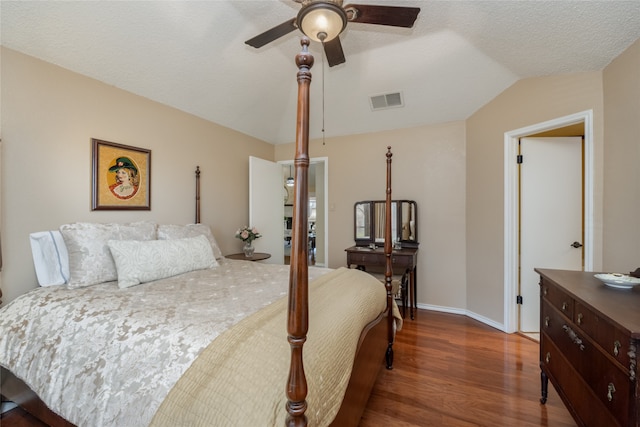 bedroom with wood finished floors, visible vents, vaulted ceiling, ceiling fan, and baseboards