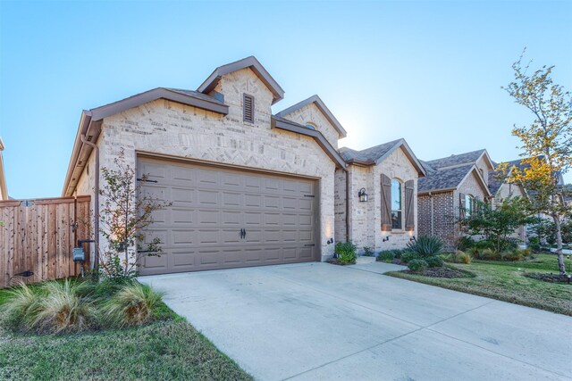 1916 Pelham Dr, Aubrey, TX 76227 - french country style house with concrete driveway, an attached garage, stone siding, and brick siding